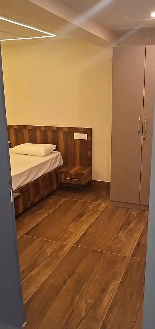 A second bedroom with a wooden headboard and a full-height wardrobe