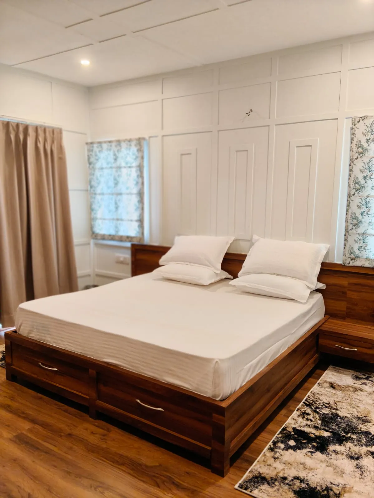 A bedroom at Namah Stay Himalayas with a wooden bed, white linen and panelled walls