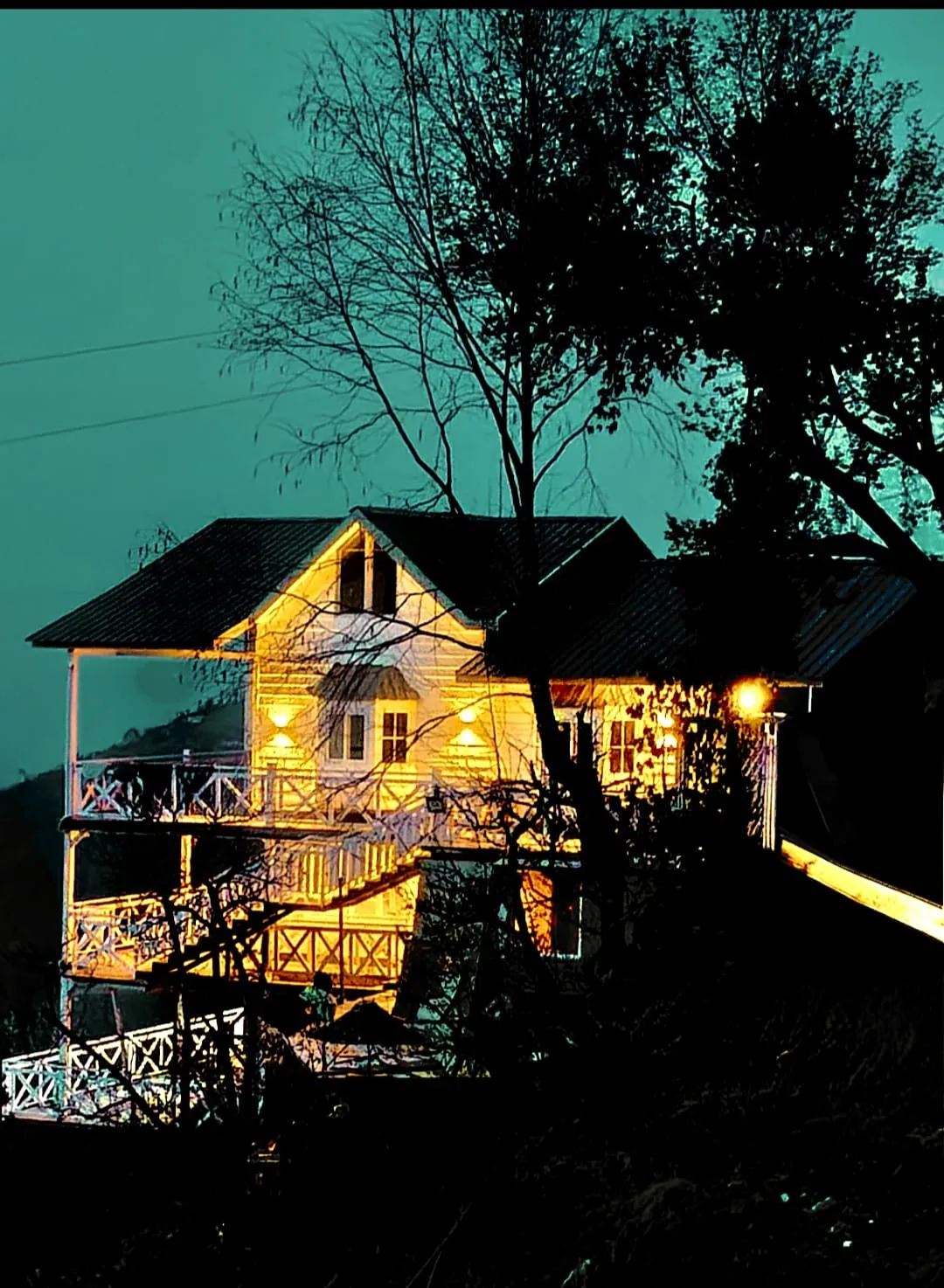 The cottage glowing with warm light at night