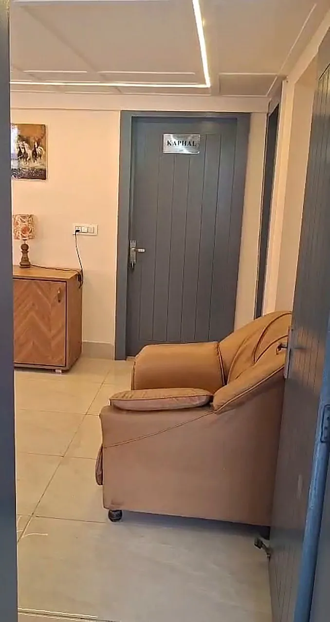 The entry corner of the lounge with an armchair and sideboard