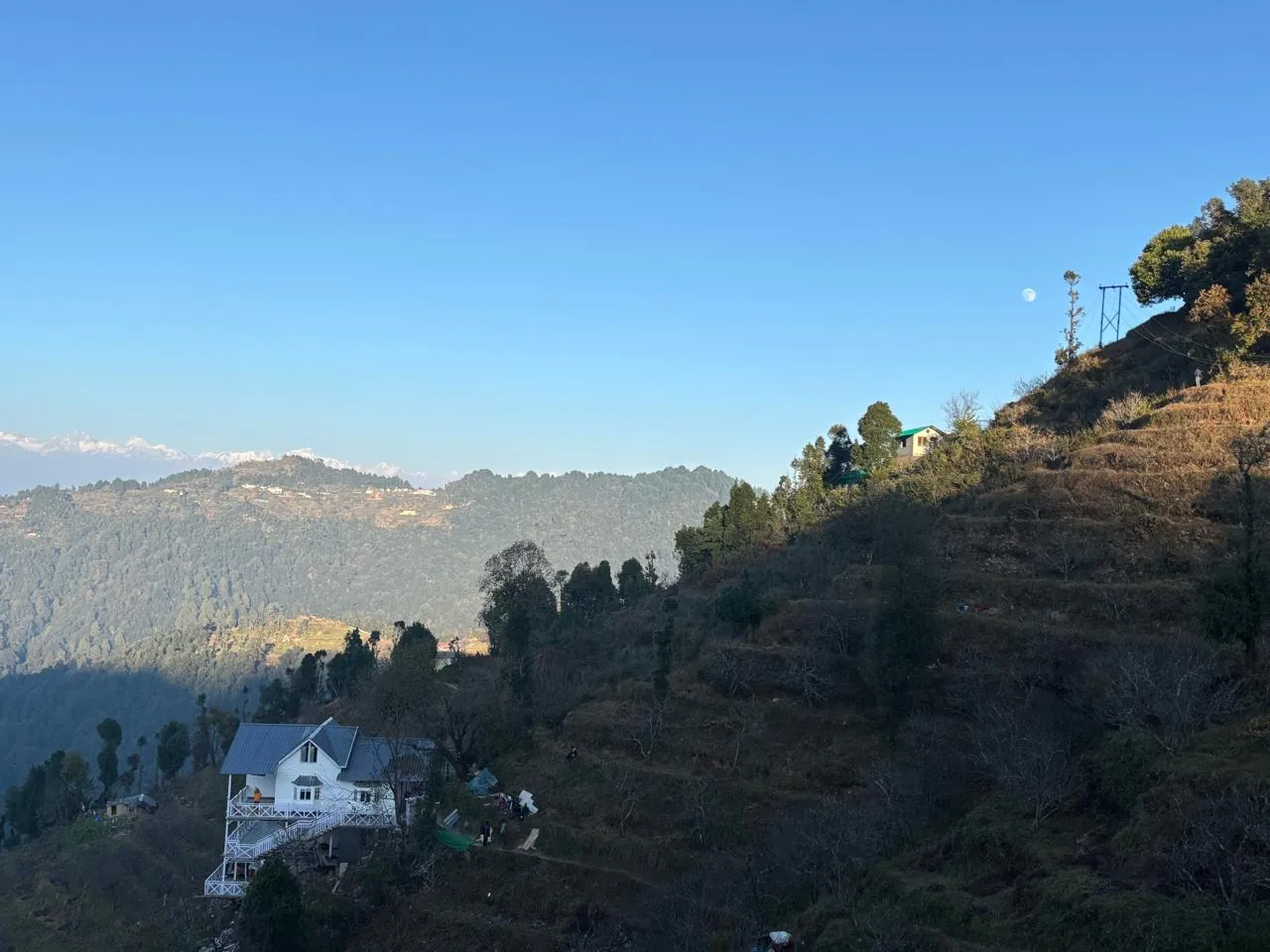 The cottage on its ridge in morning light with hills beyond