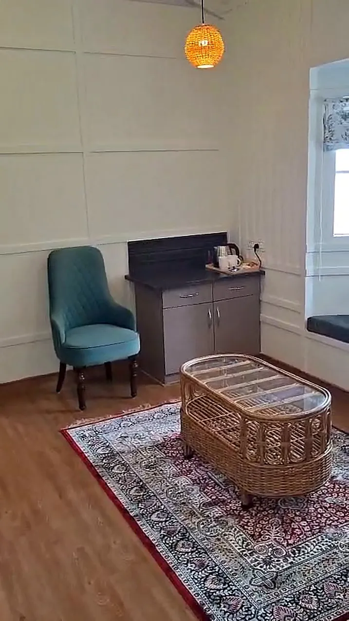 A sitting room with a cane table and a cushioned bay window seat
