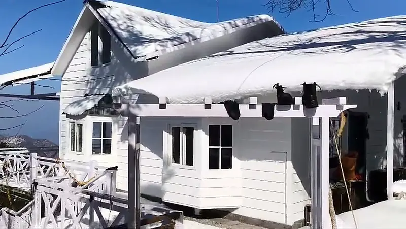 Snow piled on the porch roof at Namah Stay Himalayas, Kanatal