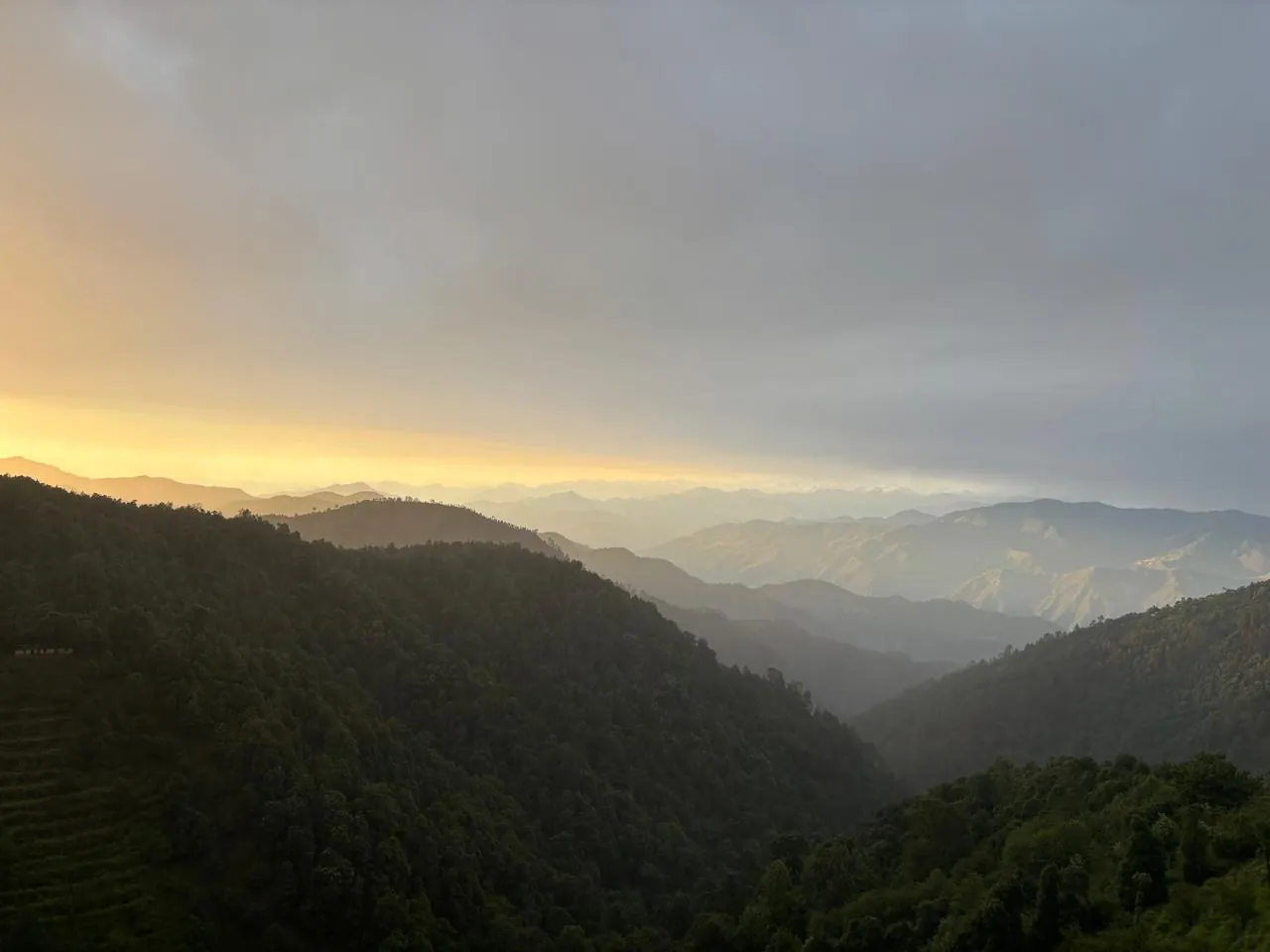 Sunset over the layered hills below Namah Stay Himalayas