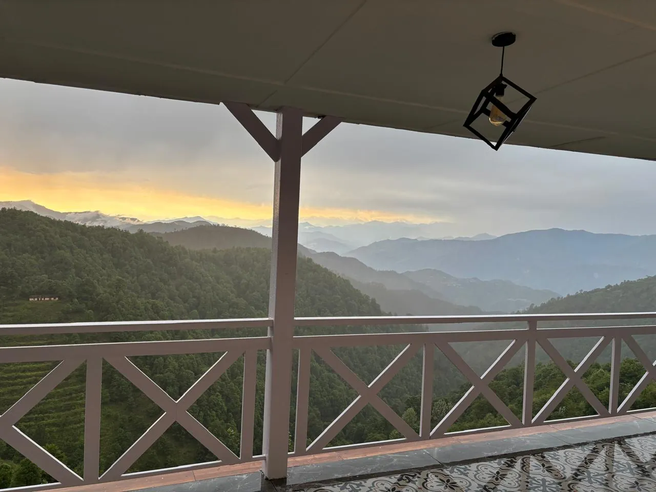 Sunset over layered hills seen from the verandah of the homestay